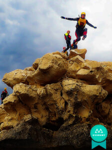 Personas haciendo coasteering entre rocas en Alicante