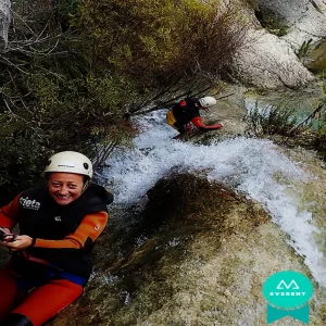 Mujer sonríe a cámara mientras desciende al agua en una ruta de barraquismo en Alicante, España