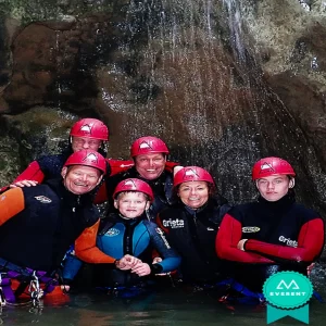Familia posa contenta en una cascada practicando Barranquismo en Valencia, España