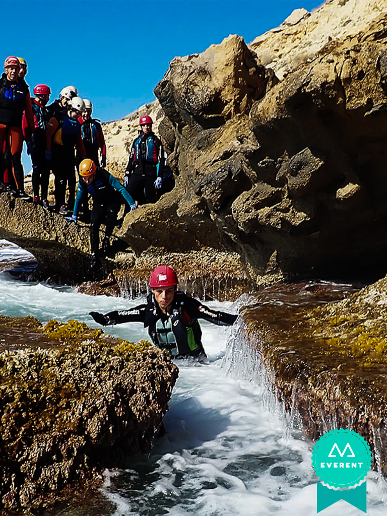 Grupo de amigos disfrutando en el agua de una aventura de coasteering en Alicante