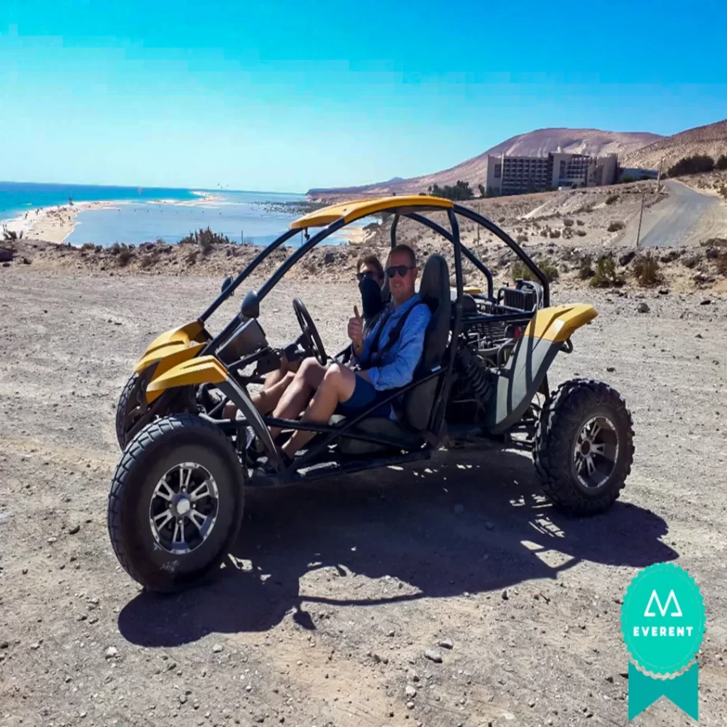Dos pasajeros saludan desde su buggy en Fuerteventura, Canarias